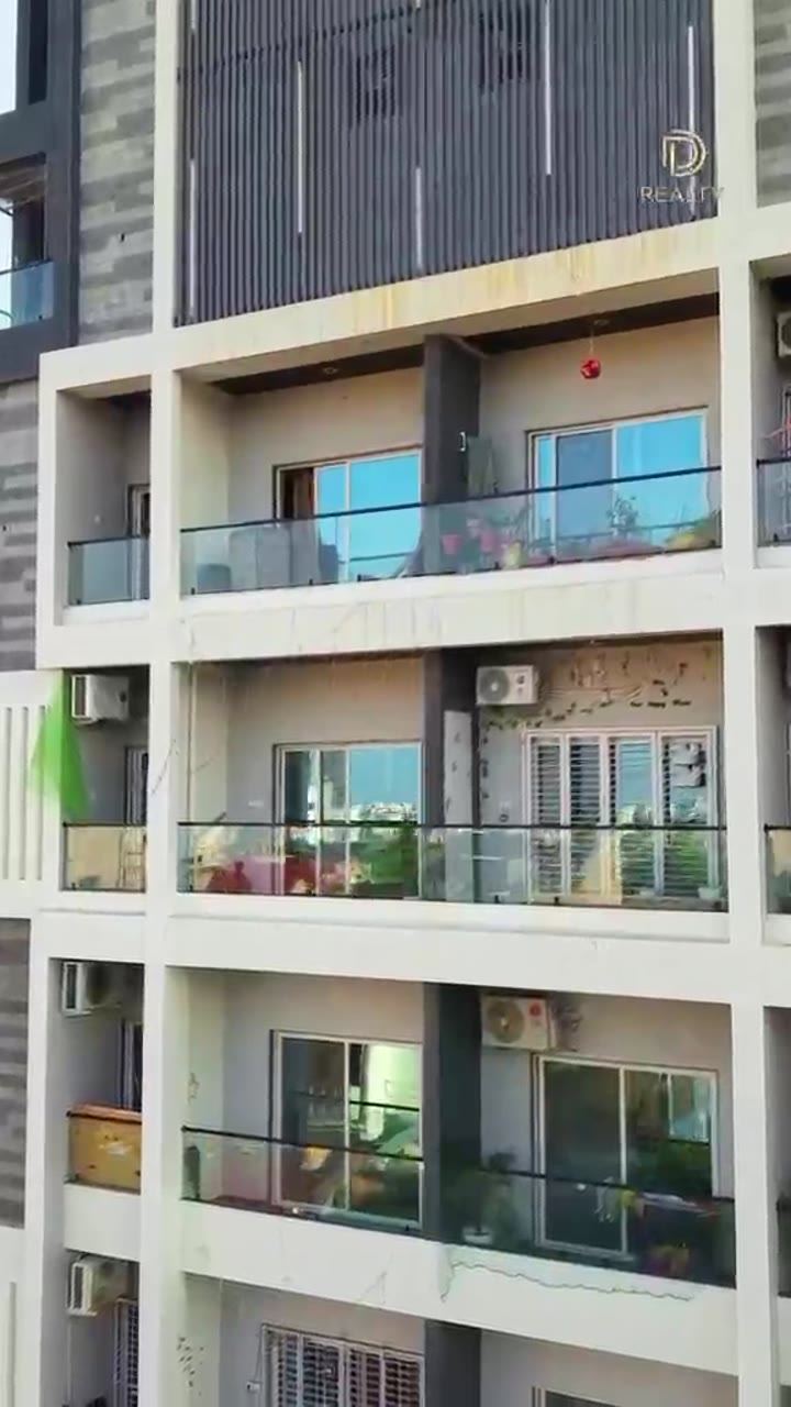 Balconies and stone-finish cladding on the Titan Residency façade.